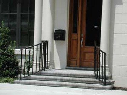 The front door of a house with a mailbox and stairs leading up to it.