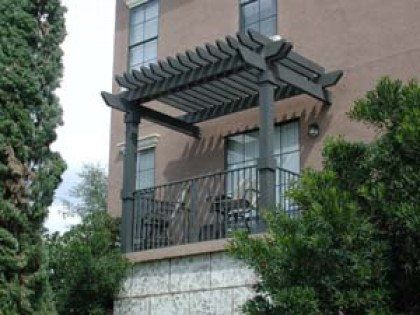 A balcony with a pergola on top of it
