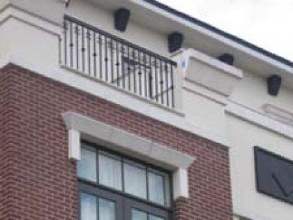 A brick building with a balcony on the top of it.
