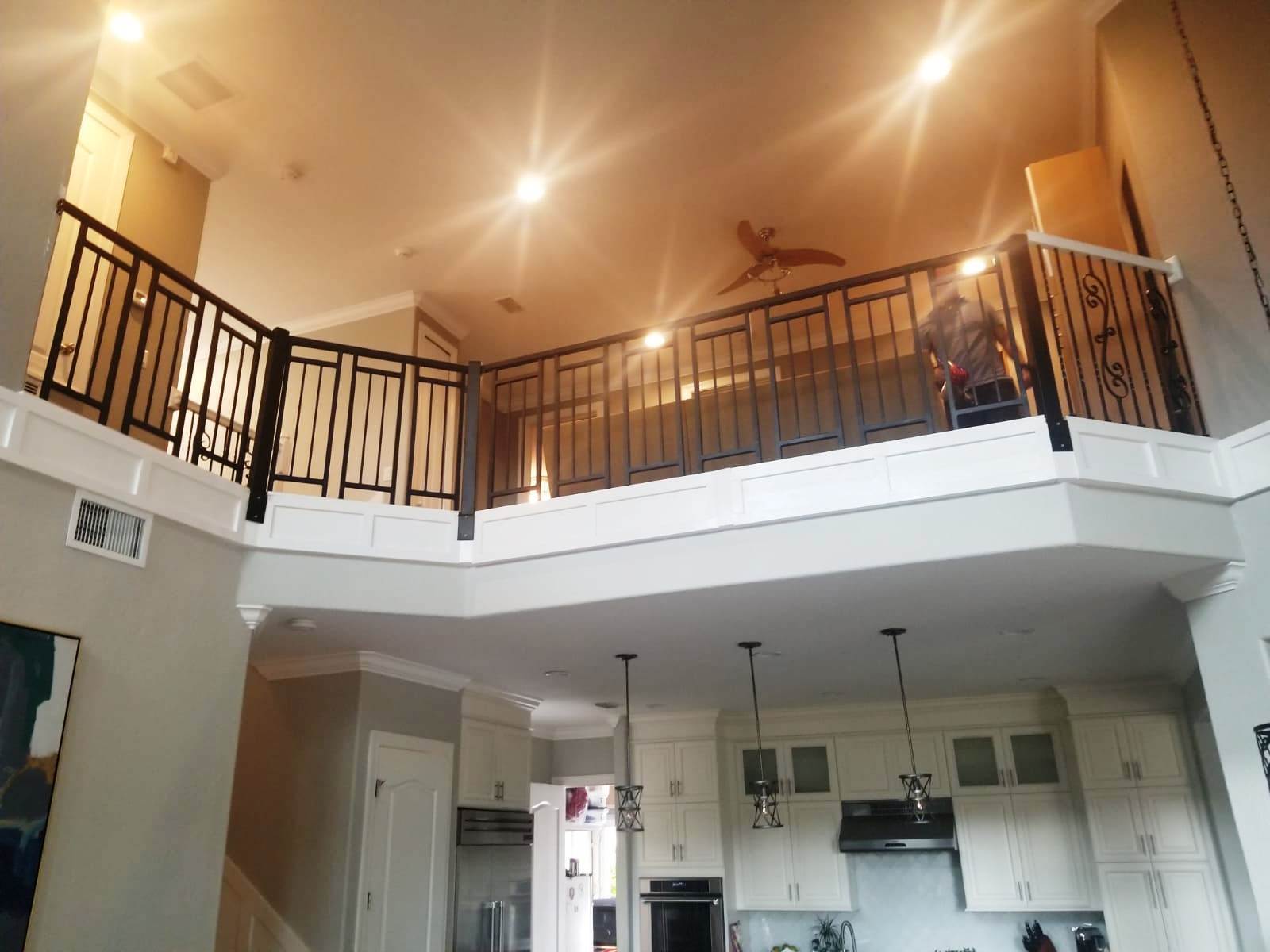 A kitchen with a balcony and a ceiling fan.
