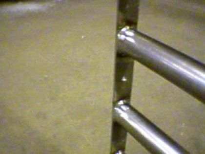 A close up of a metal railing on a concrete floor.