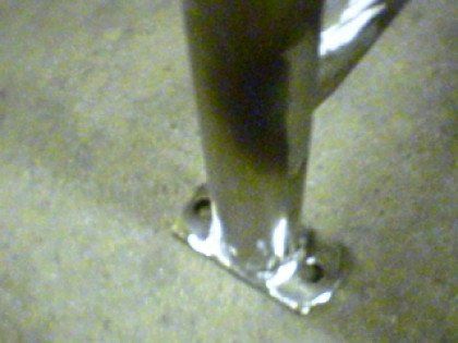 A metal pole is sitting on a concrete floor.