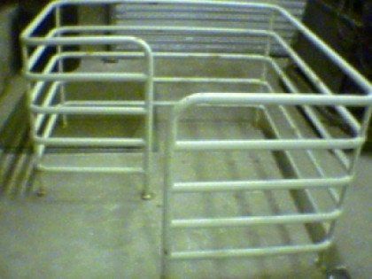 A white metal fence is sitting on a concrete floor