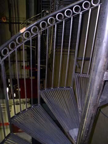 A spiral staircase with a metal railing in a building.