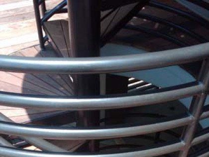 A close up of a spiral staircase with a metal railing.