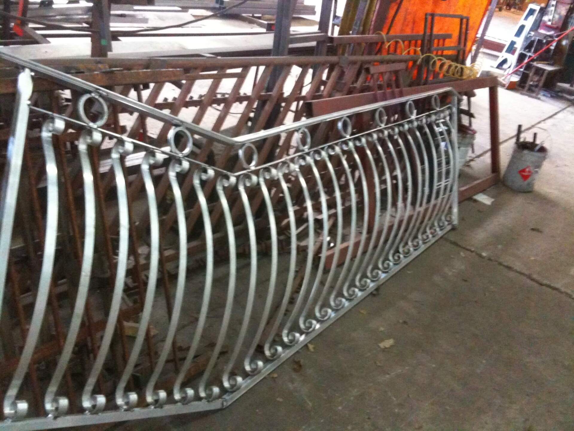 A metal railing is being built in a factory
