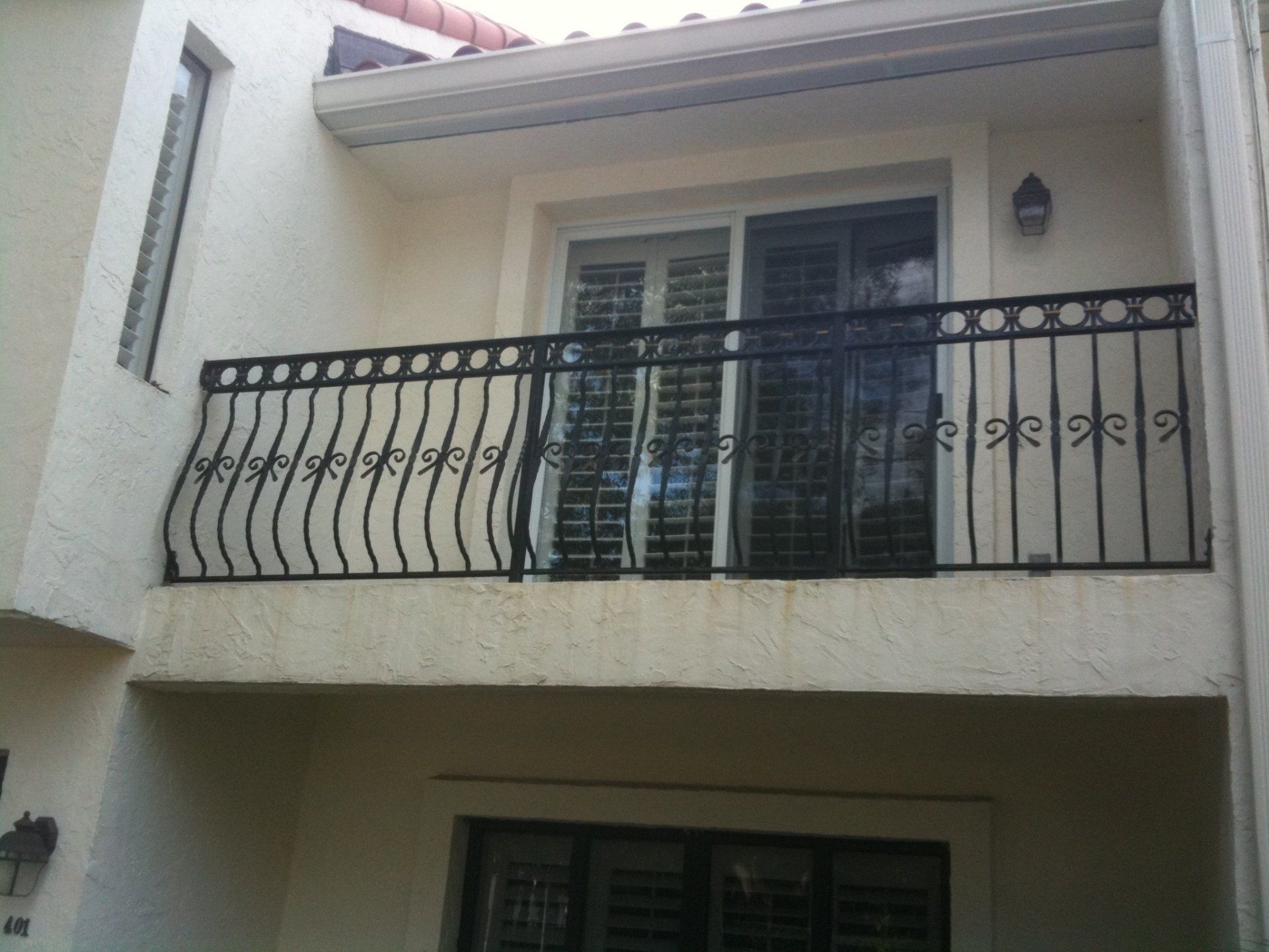 A balcony on the side of a building with a black railing