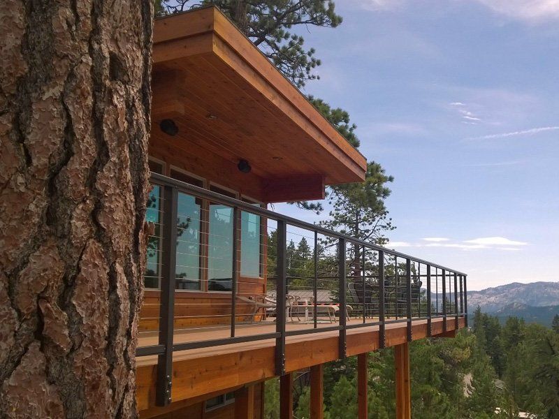 A house with a balcony that is surrounded by trees