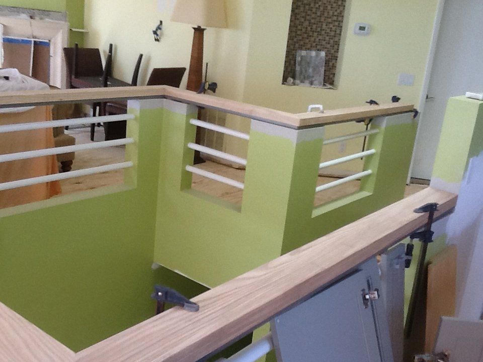 A room with green walls and a wooden railing