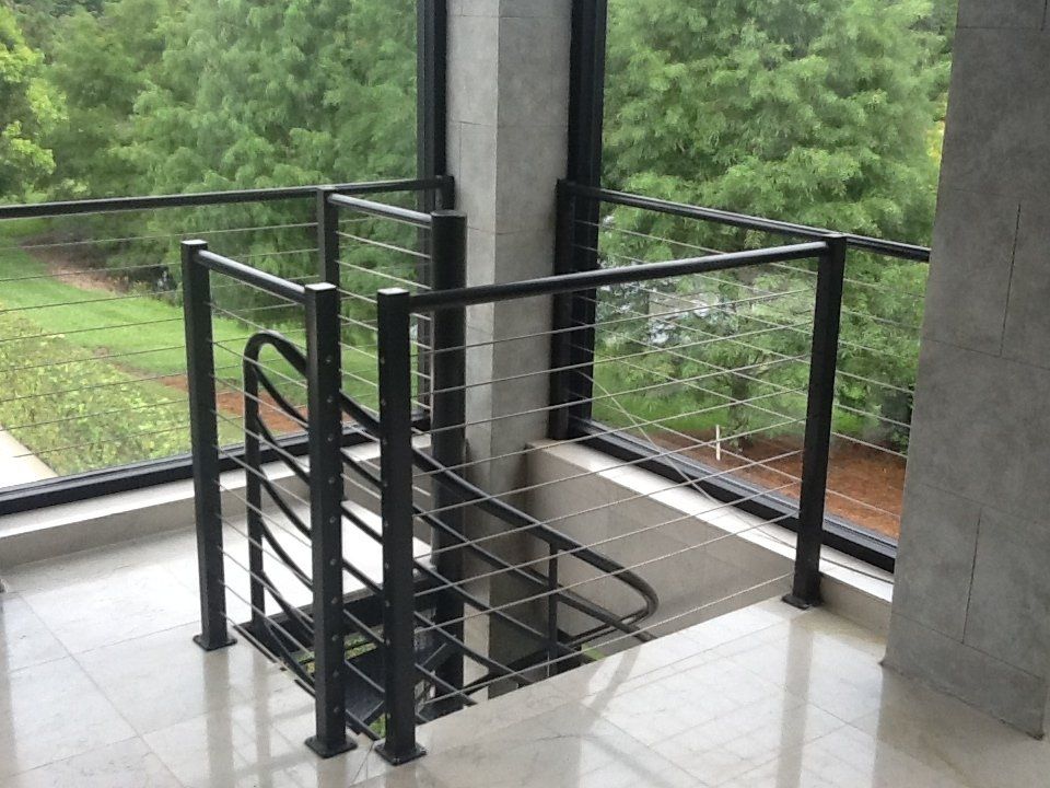 A spiral staircase with a black railing and a large window