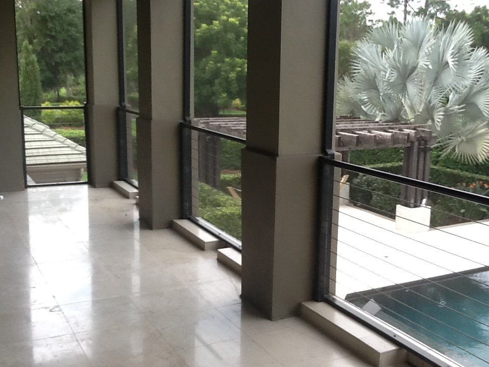 A room with a lot of windows and a pool in the background