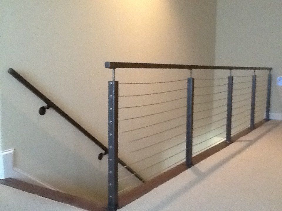A staircase with a wire railing and a handrail