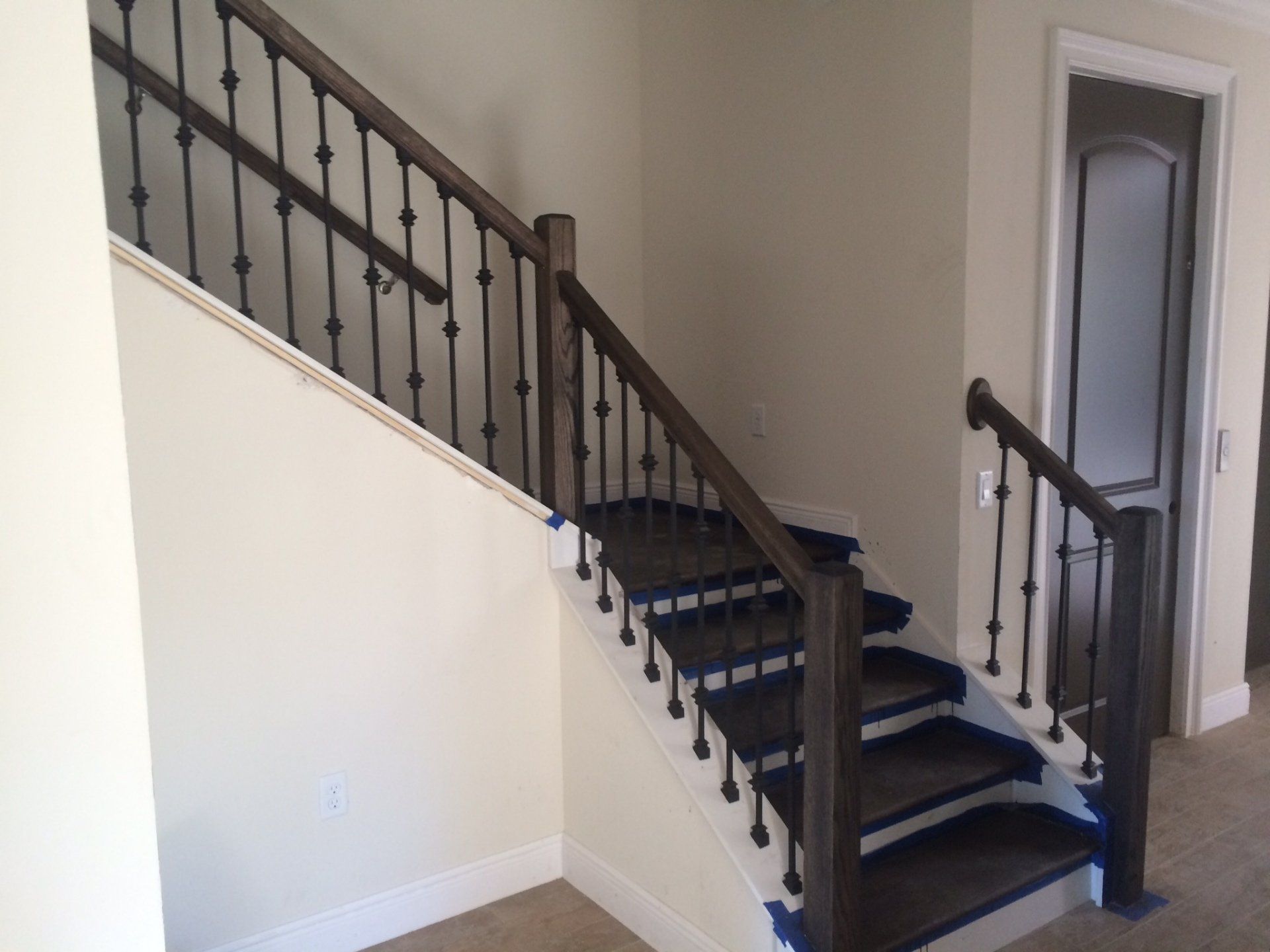 A staircase with a wrought iron railing in a house