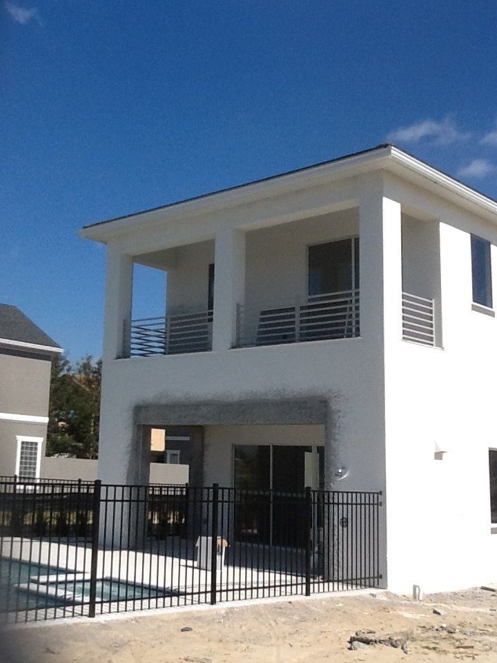 A white house with a black fence around it