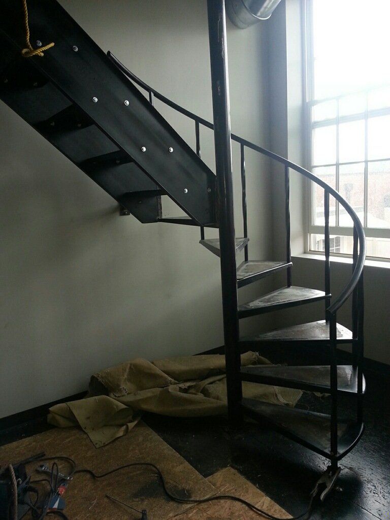 A spiral staircase in a room with a window