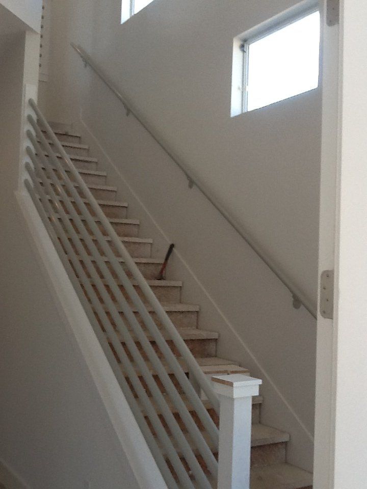 A staircase with a white railing and a window