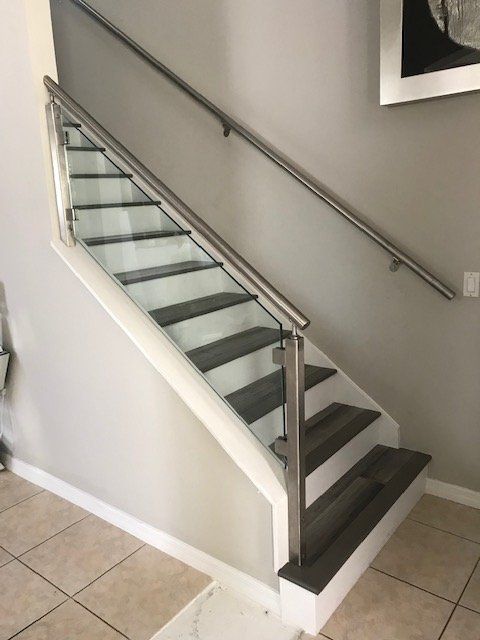 A staircase with a stainless steel railing and glass steps