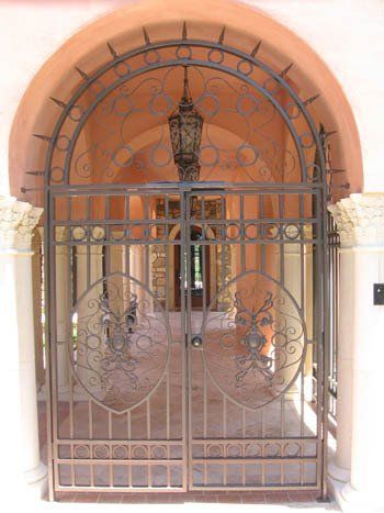 A wrought iron gate with a lantern hanging from it