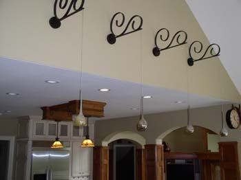 A kitchen with a lot of lights hanging from the ceiling and a clock on the wall.