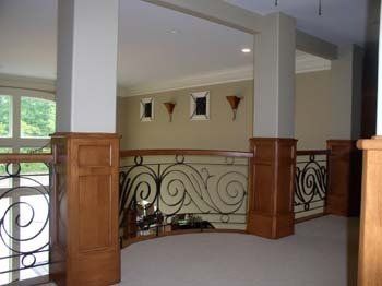 A room with a balcony and a wrought iron railing.