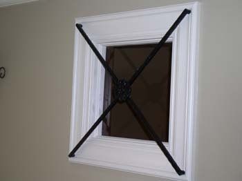 A white window with a black frame is hanging on a wall.