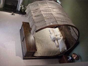 A bed with a canopy made of sheet music in a bedroom.