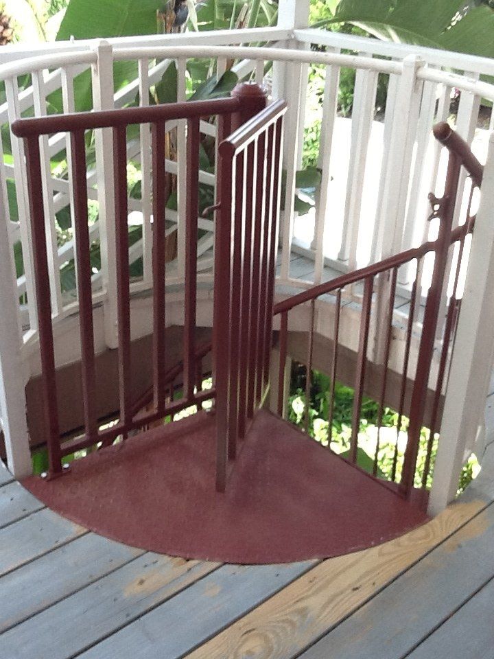A spiral staircase on a deck with a white railing