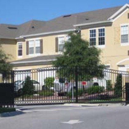 A large house with a sliding gate in front of it.