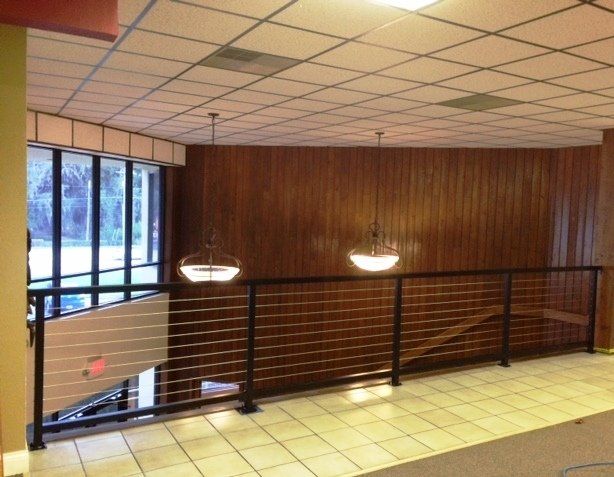 A staircase with a railing and a red exit sign