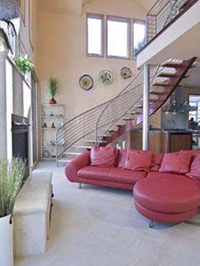 A living room with a red couch and stairs