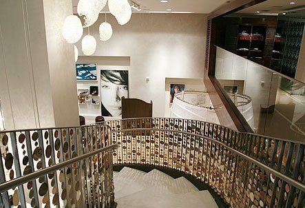 A staircase with a metal railing and a picture of a woman on the wall