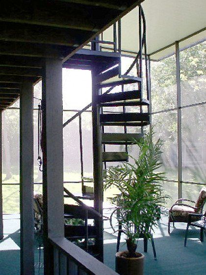 A screened in porch with a spiral staircase