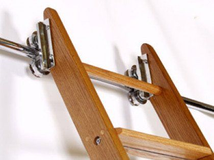 A wooden ladder is attached to a metal railing