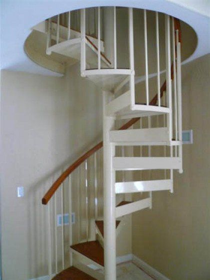 A white spiral staircase with a wooden railing