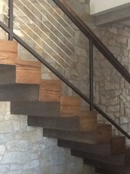A staircase with a metal railing and wooden steps