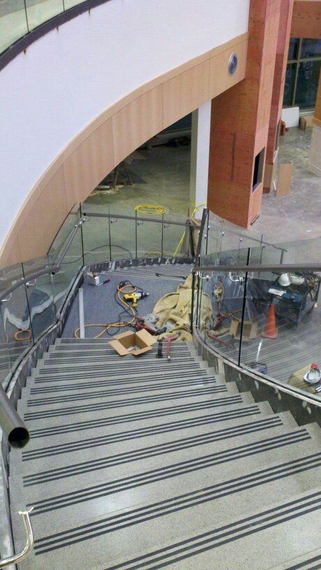 A staircase with a glass railing in a building under construction.