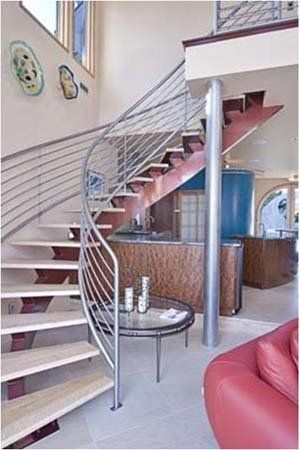A living room with a spiral staircase and a red chair