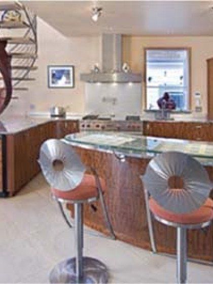 A kitchen with a glass counter top and stools