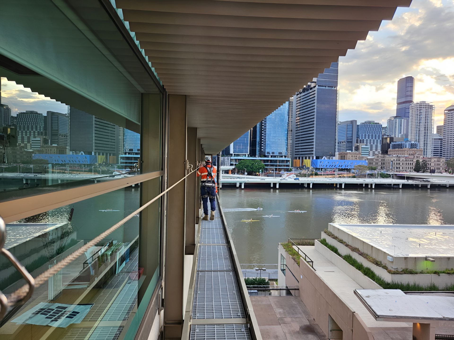 Person Walking on a Bridge With a River and City Skyline in the Background — Australian Asset Compliance in Brisbane, QLD