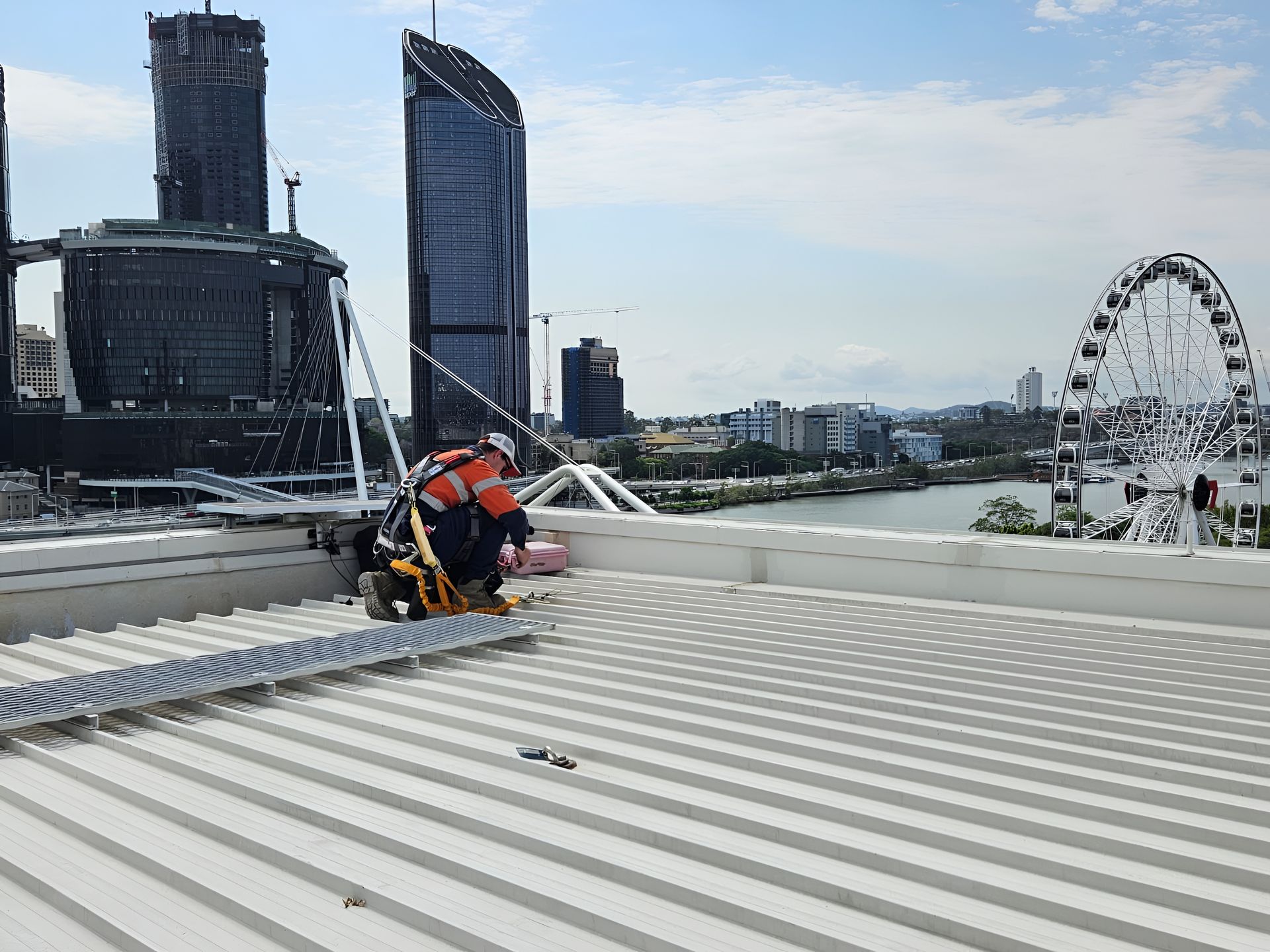 Roofer Working on a Corrugated Metal Roof With Skyscrapers — Australian Asset Compliance in Gympie, QLD