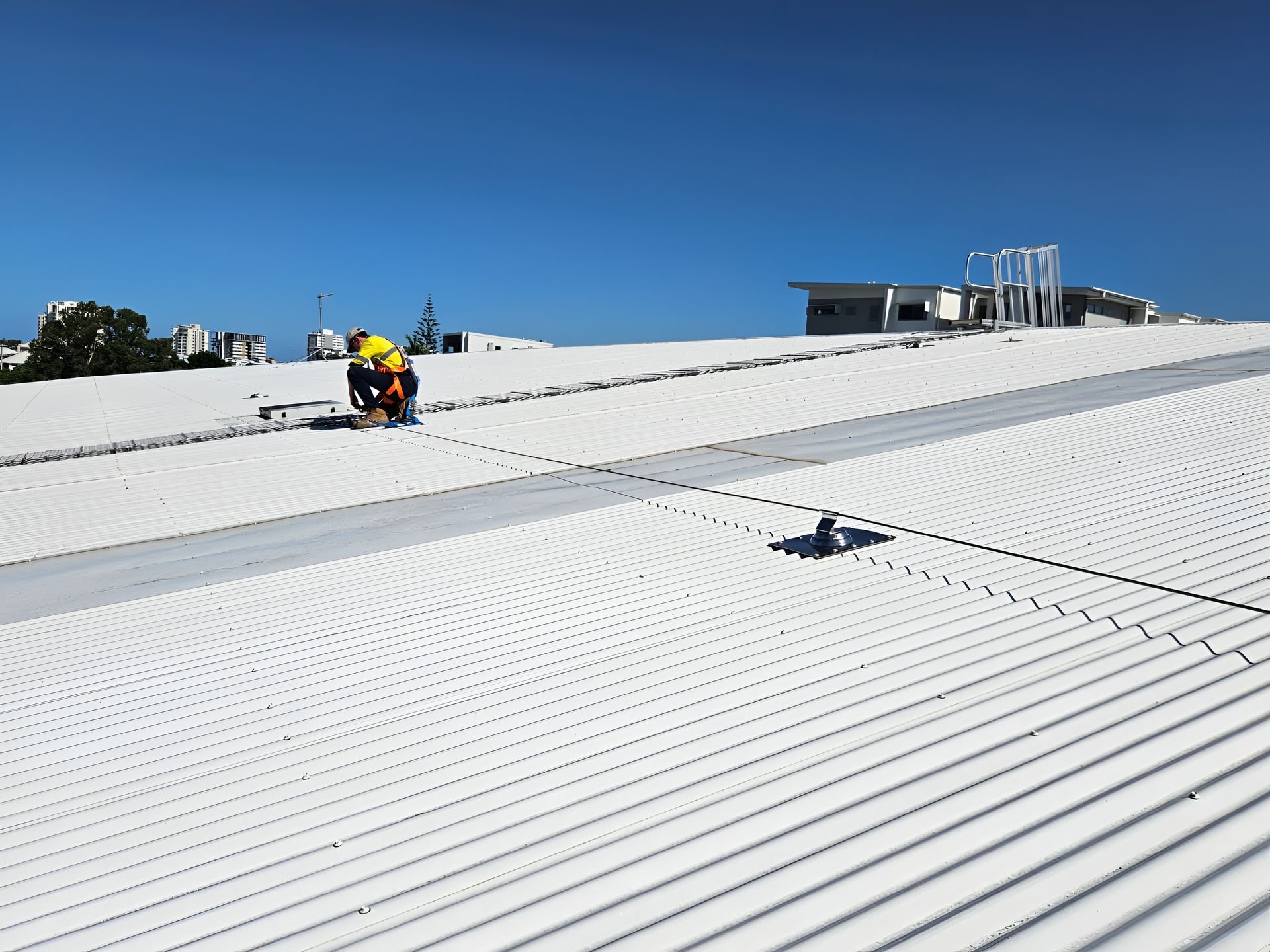 Workers on a White Metal Roof With Safety Equipment — Australian Asset Compliance in Gold Coast, QLD