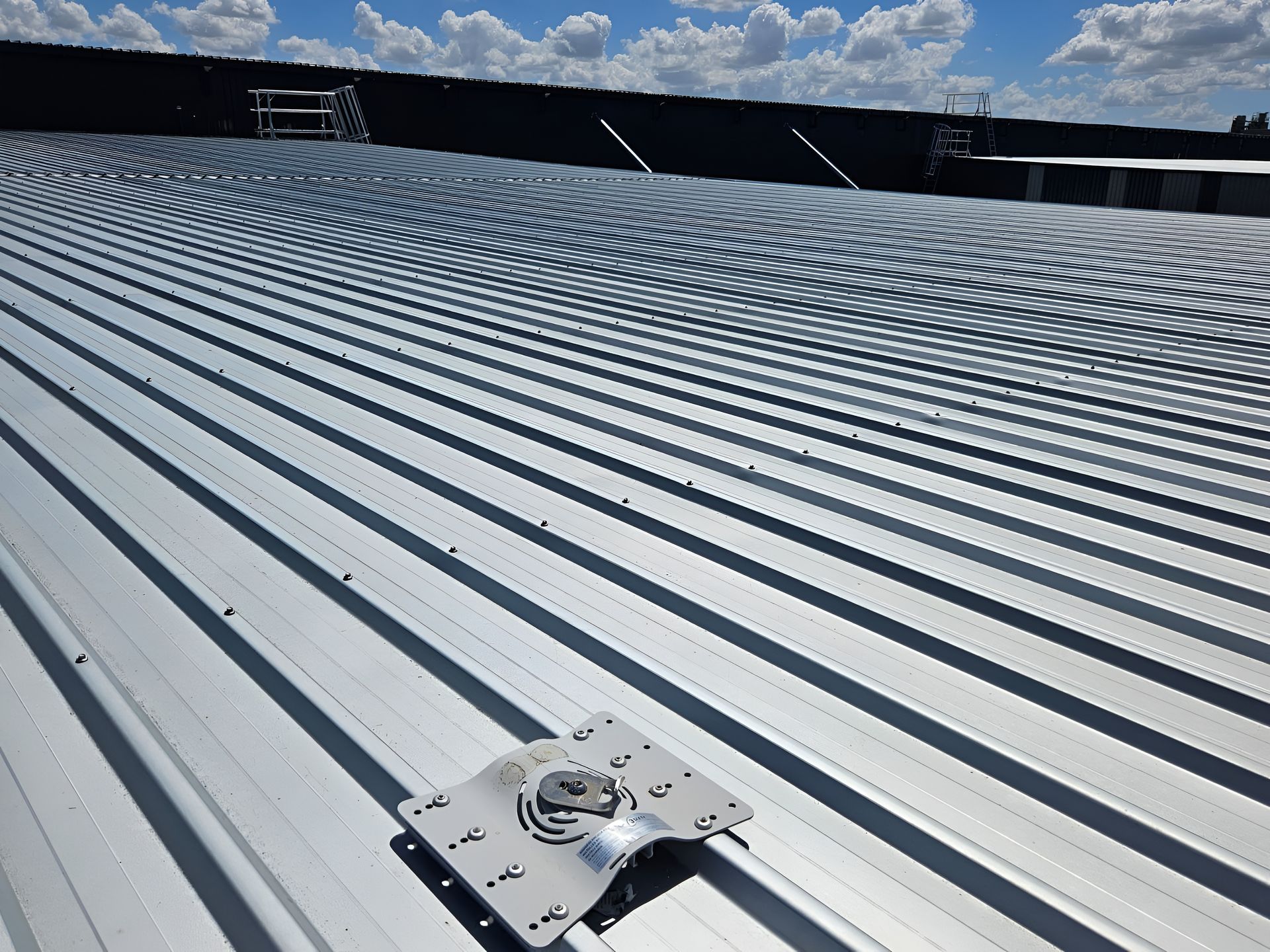 Metal roof with a mounting bracket under a blue sky. — Australian Asset Compliance in Brisbane, QLD