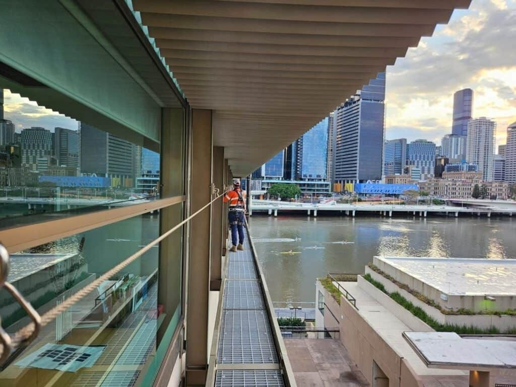 Person in Safety Vest Walks on A Walkway, Overlooking a River — Australian Asset Compliance in Glanmire, QLD