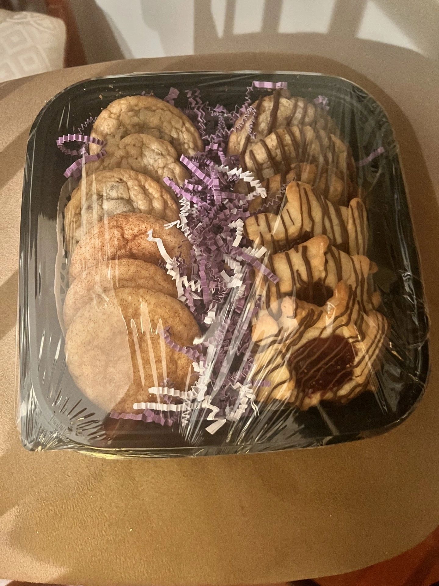 A tray of cookies and donuts is sitting on a table.