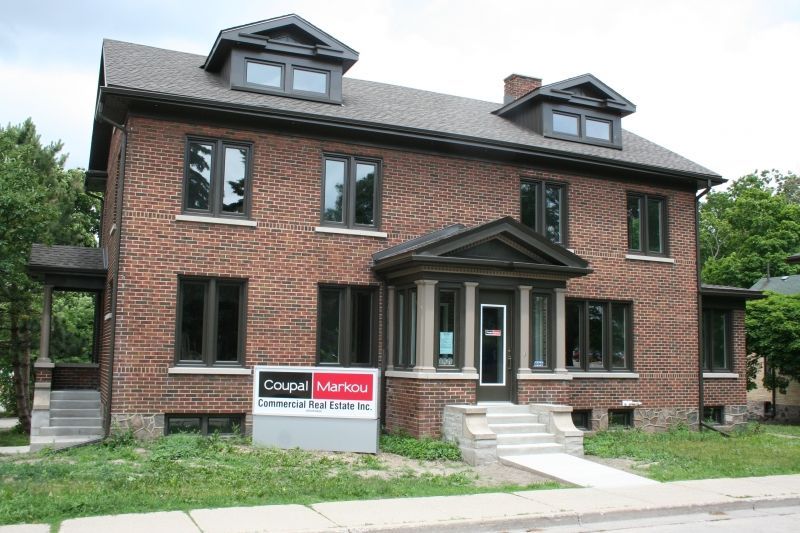 Brick building with dark trim and a sign for