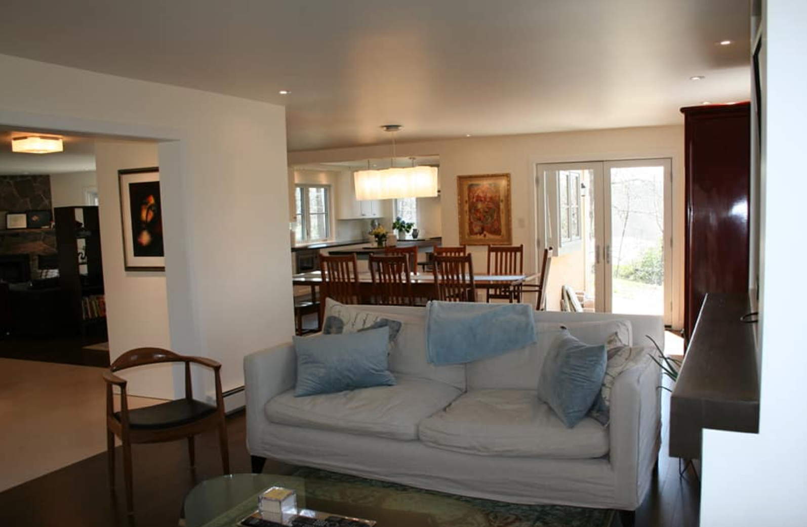 Living room with white sofa, open to dining area and kitchen.