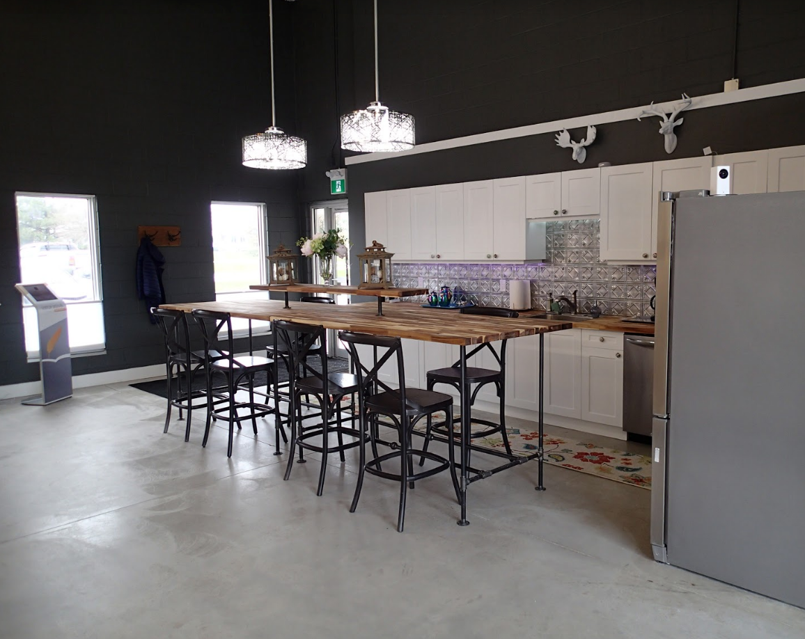 Modern kitchen with island seating, white cabinets, and dark gray walls.
