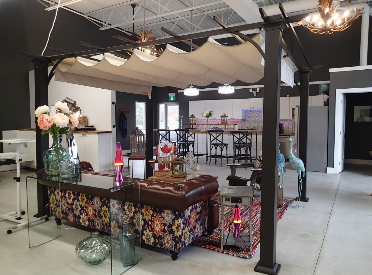 A decorative lounge area inside a building, featuring a floral sofa and an overhead canopy.