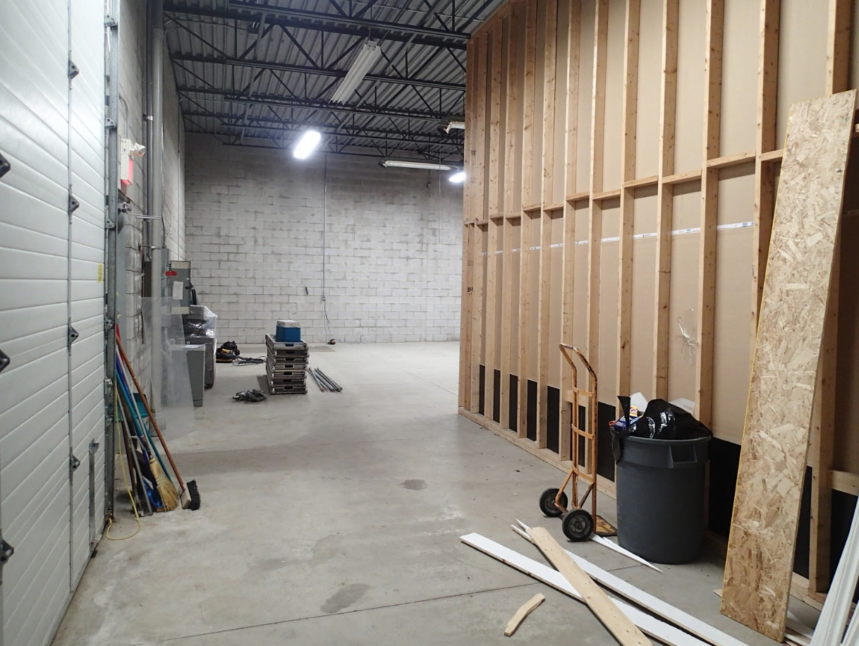 Construction site: Warehouse interior with unfinished walls and concrete floor.