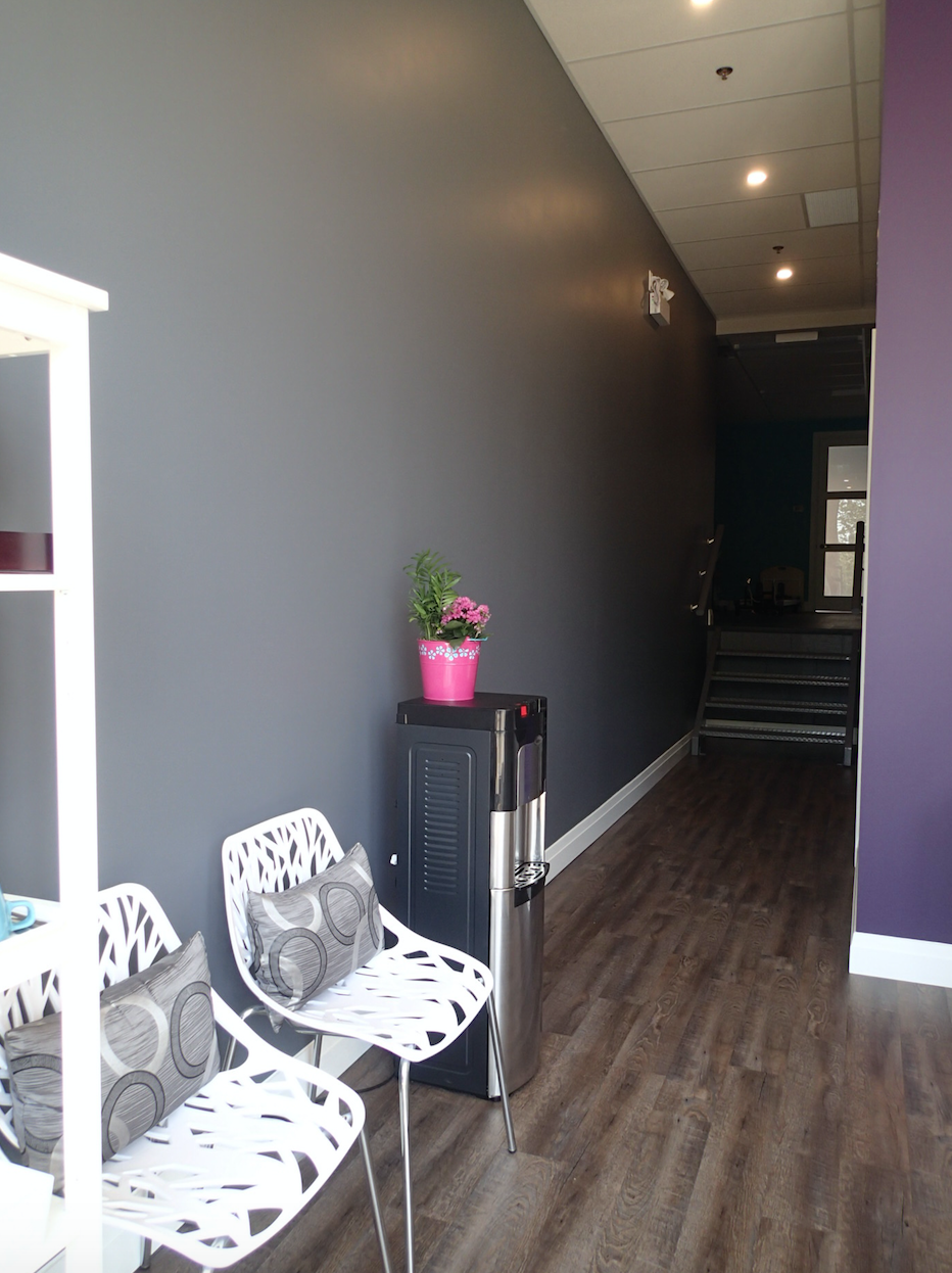 Waiting area with chairs, water cooler, and purple and gray walls.